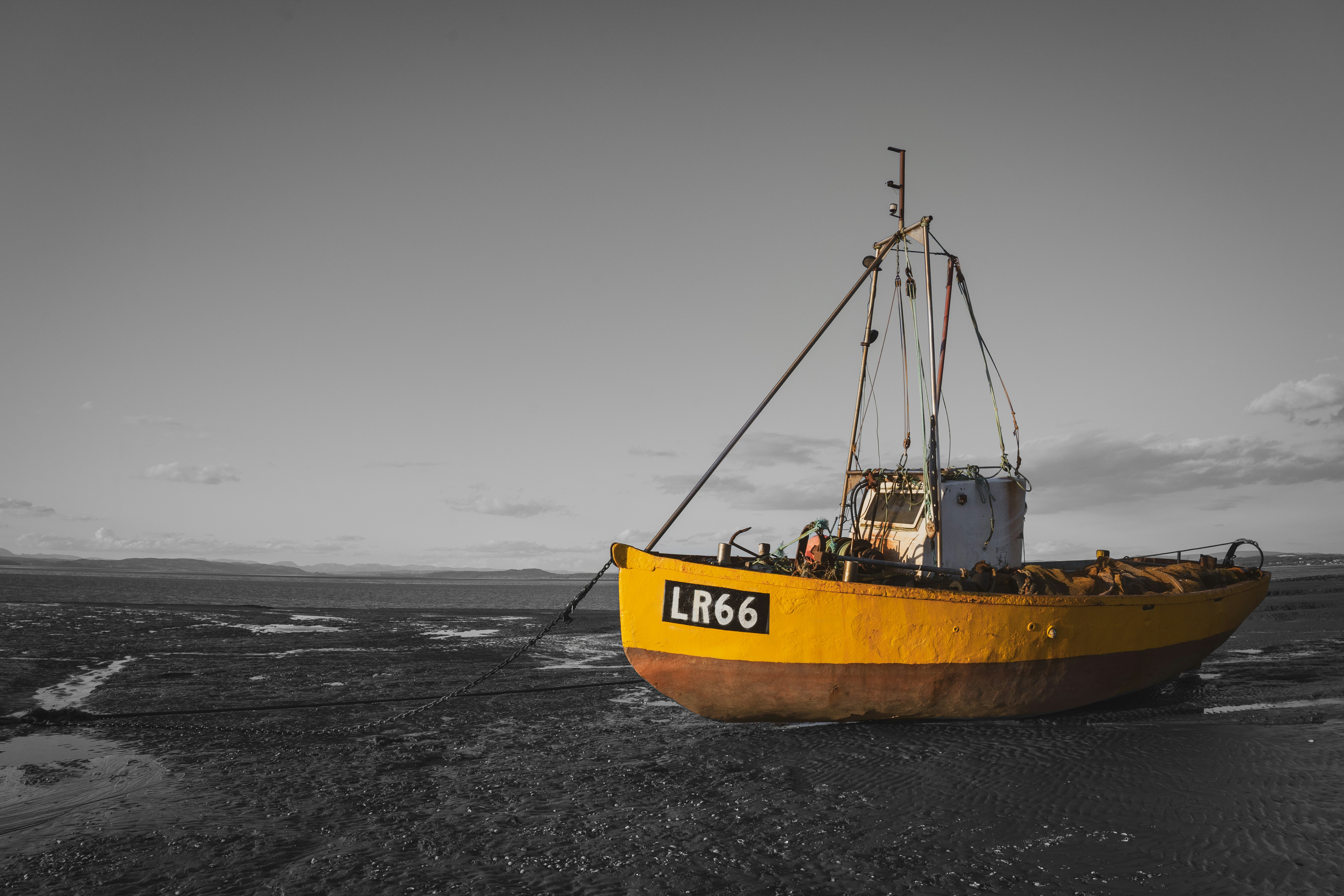 yellow and brown boat on black sand during daytime